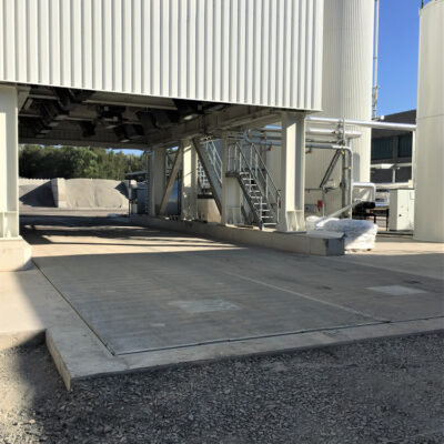 20 m long and 7 m wide underfloor truck scale WD 10o in the loading road of an asphalt mixing plant, covering of the centre gap between both scale bridges with heavy T-steel profile flush with the surface.